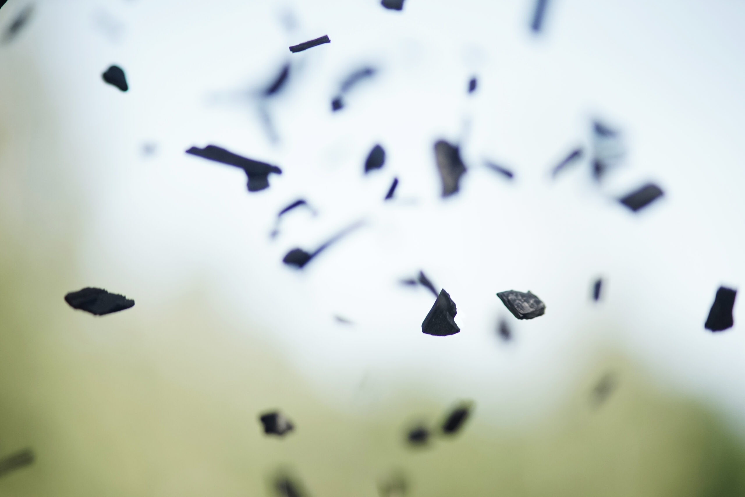 Biokol som faller i luften med suddig grön bakgrund och himmel