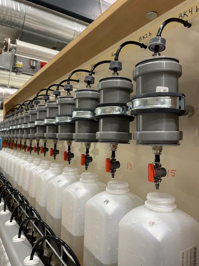 Bild på ett filtertestsystem där det droppar vatten från kolonner ner i flaskor