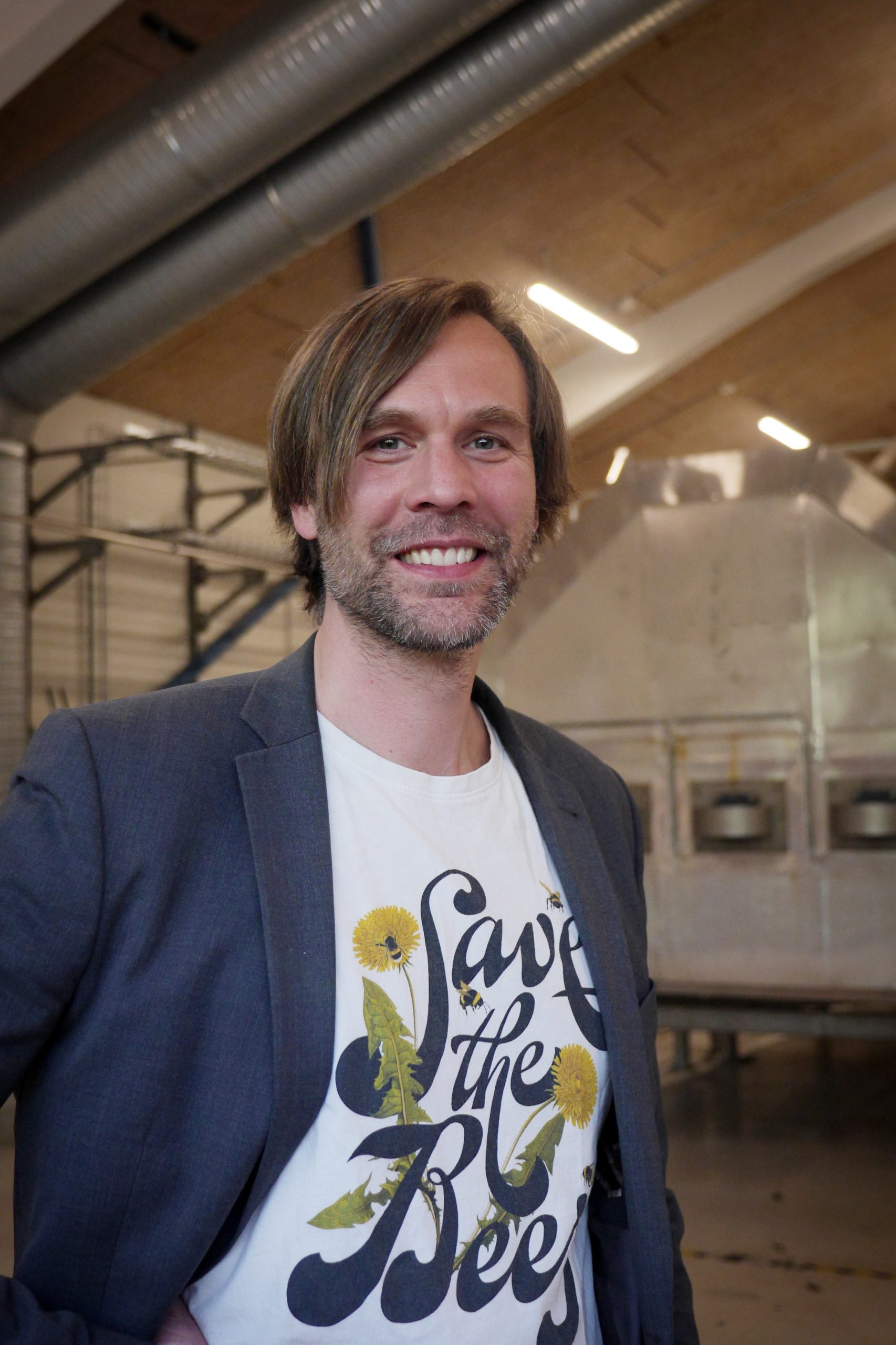 Porträtt på Mattias inomhus framför en biokolanläggning